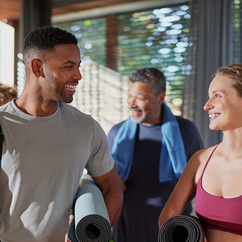Man and woman holding yoga mats