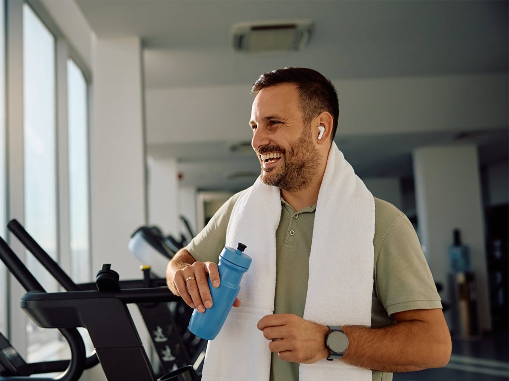 Man in gym with water bottle and towel