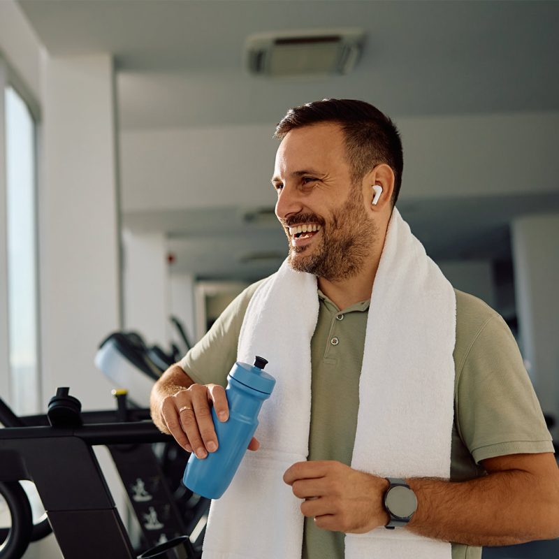 Man in gym with water bottle and towel